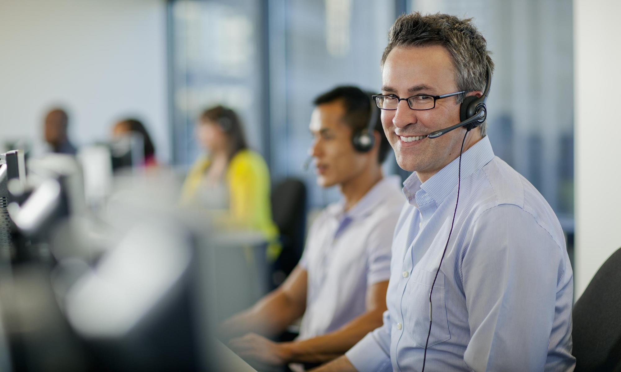 Smiling man with headset at customer center