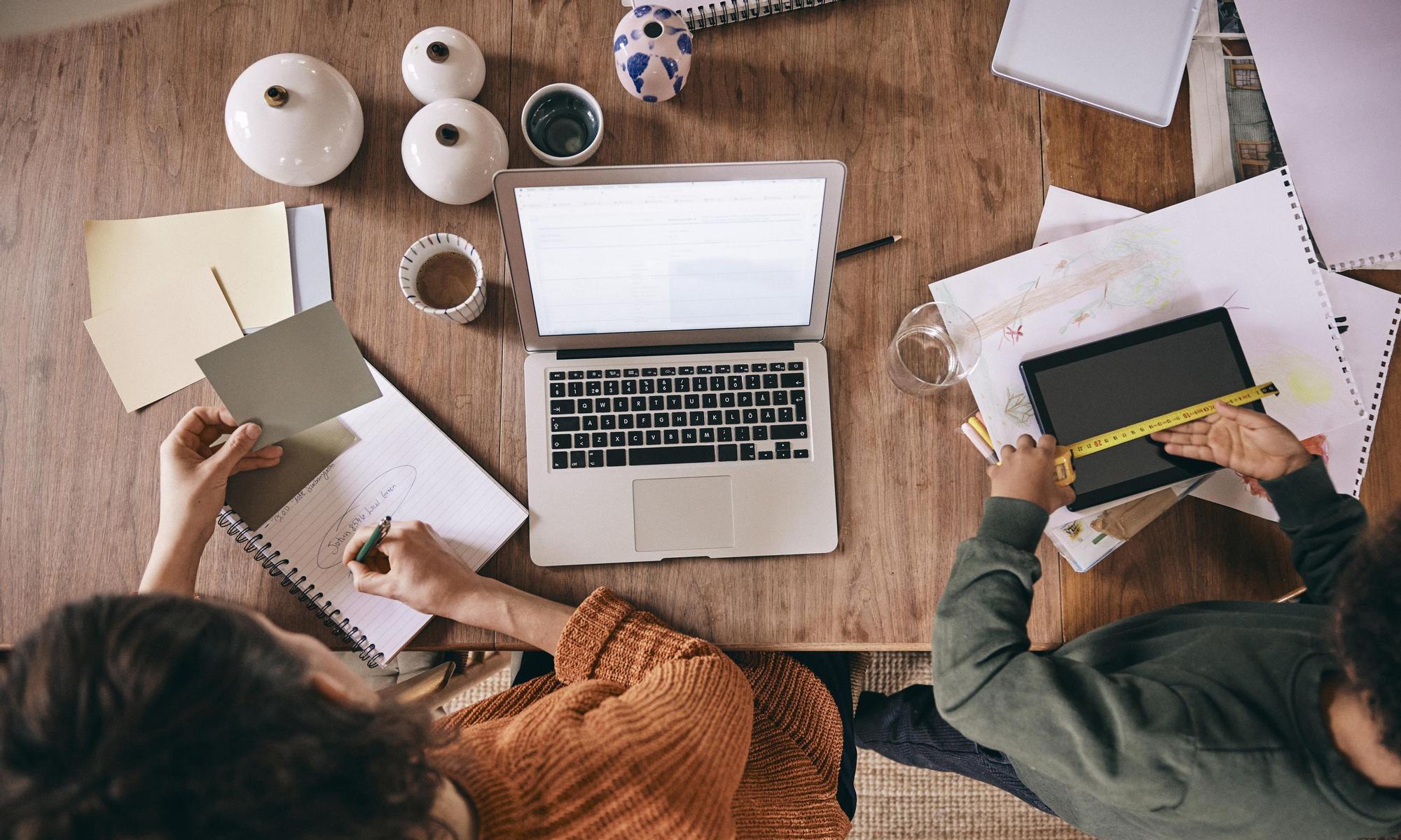 Two people working in front of the computer together